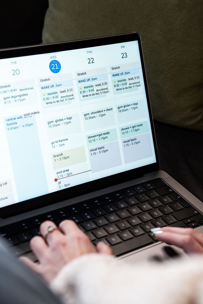 The Art of Drawing Readers In: Your attractive post title goes here A woman types on a laptop while planning her weekly schedule using a digital calendar.